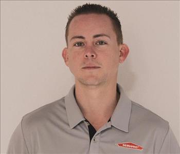 A SERVPRO employee is shown in a gray shirt with SERVPRO logo